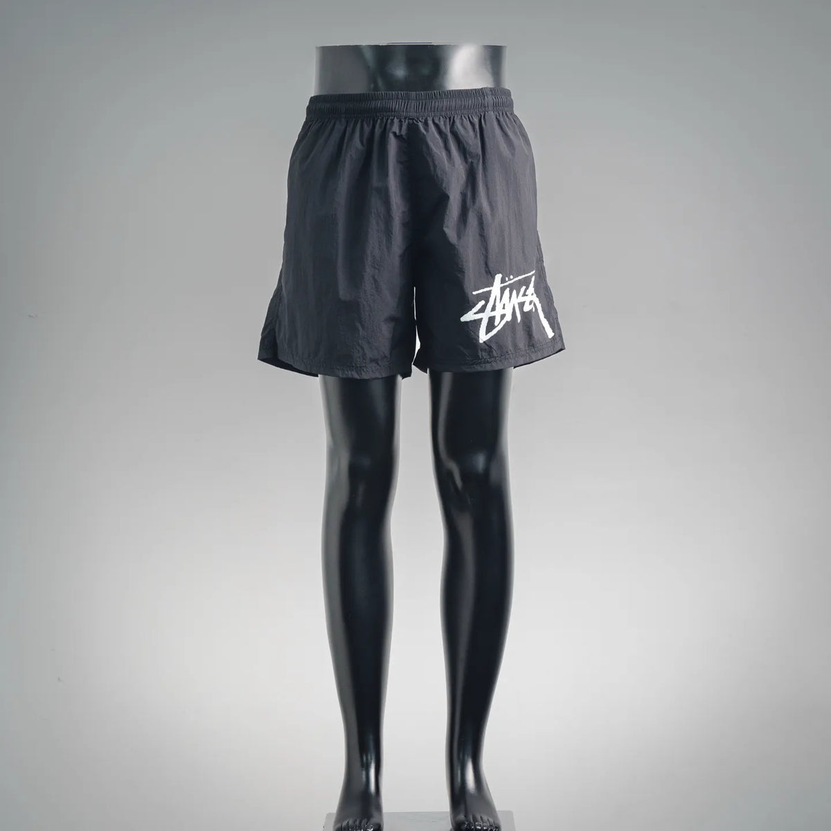 Stussy black shorts with elastic waistband and white Stussy logo on leg