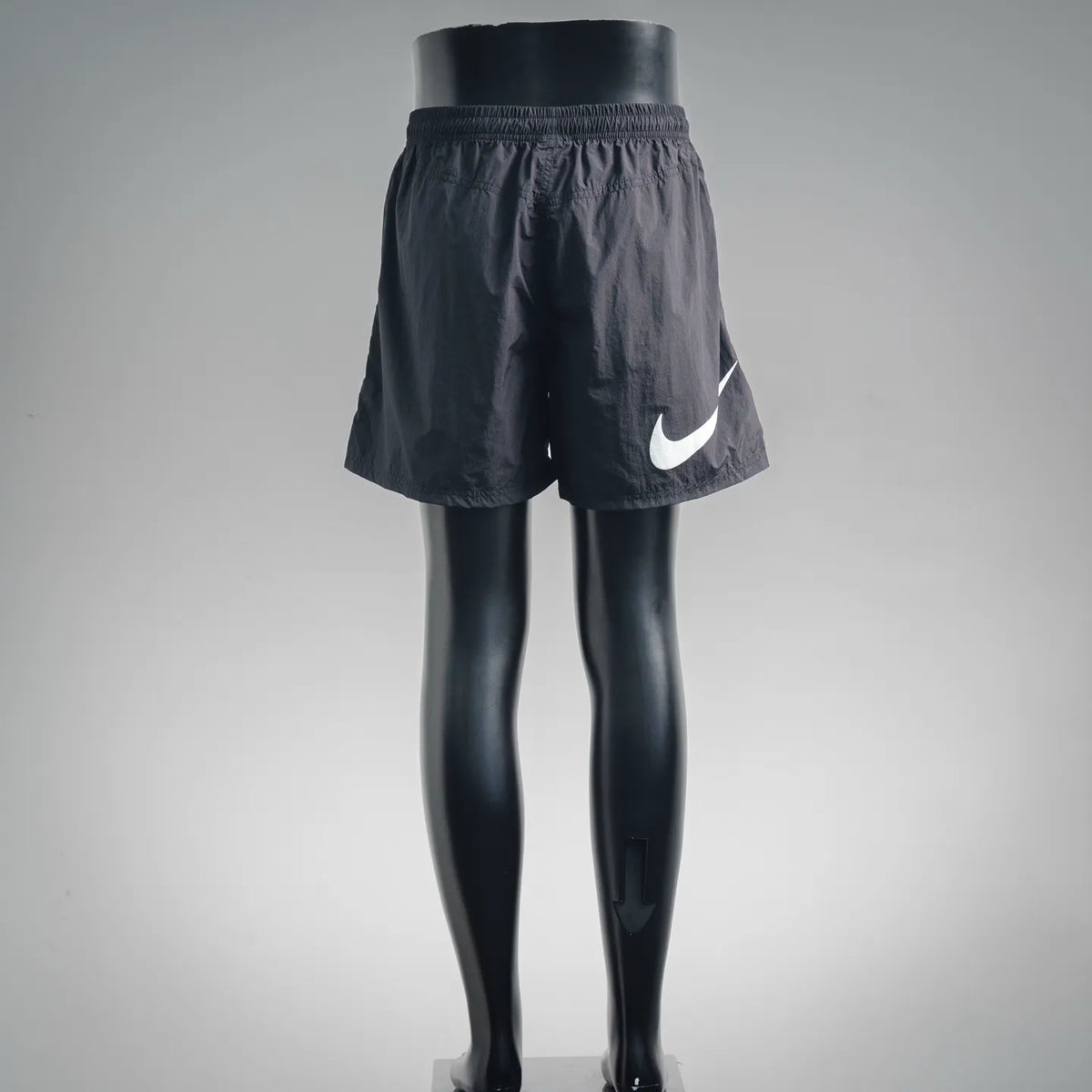Stussy black shorts with elastic waistband and white Nike swoosh on leg
