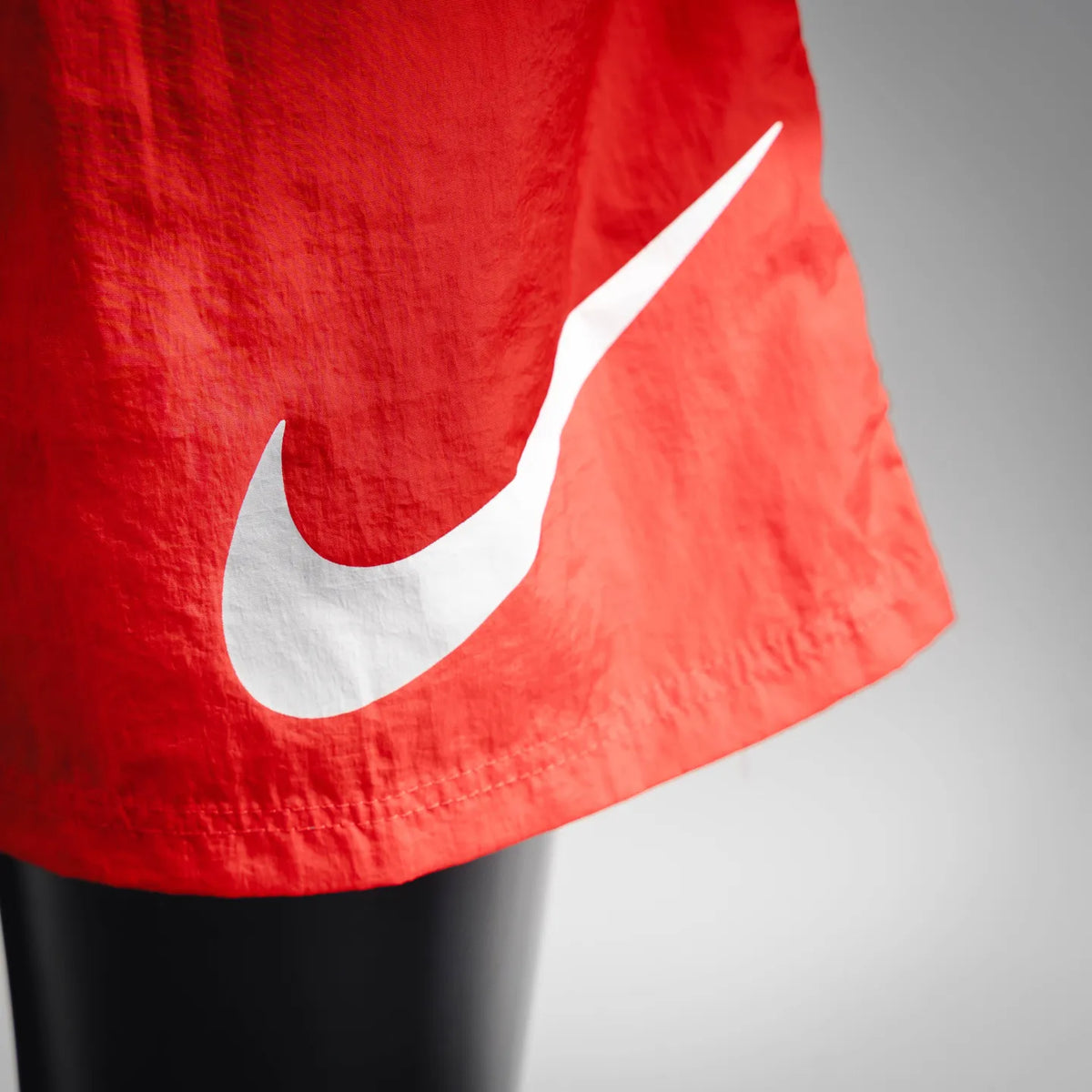 Red shorts hem with white Nike swoosh logo detail