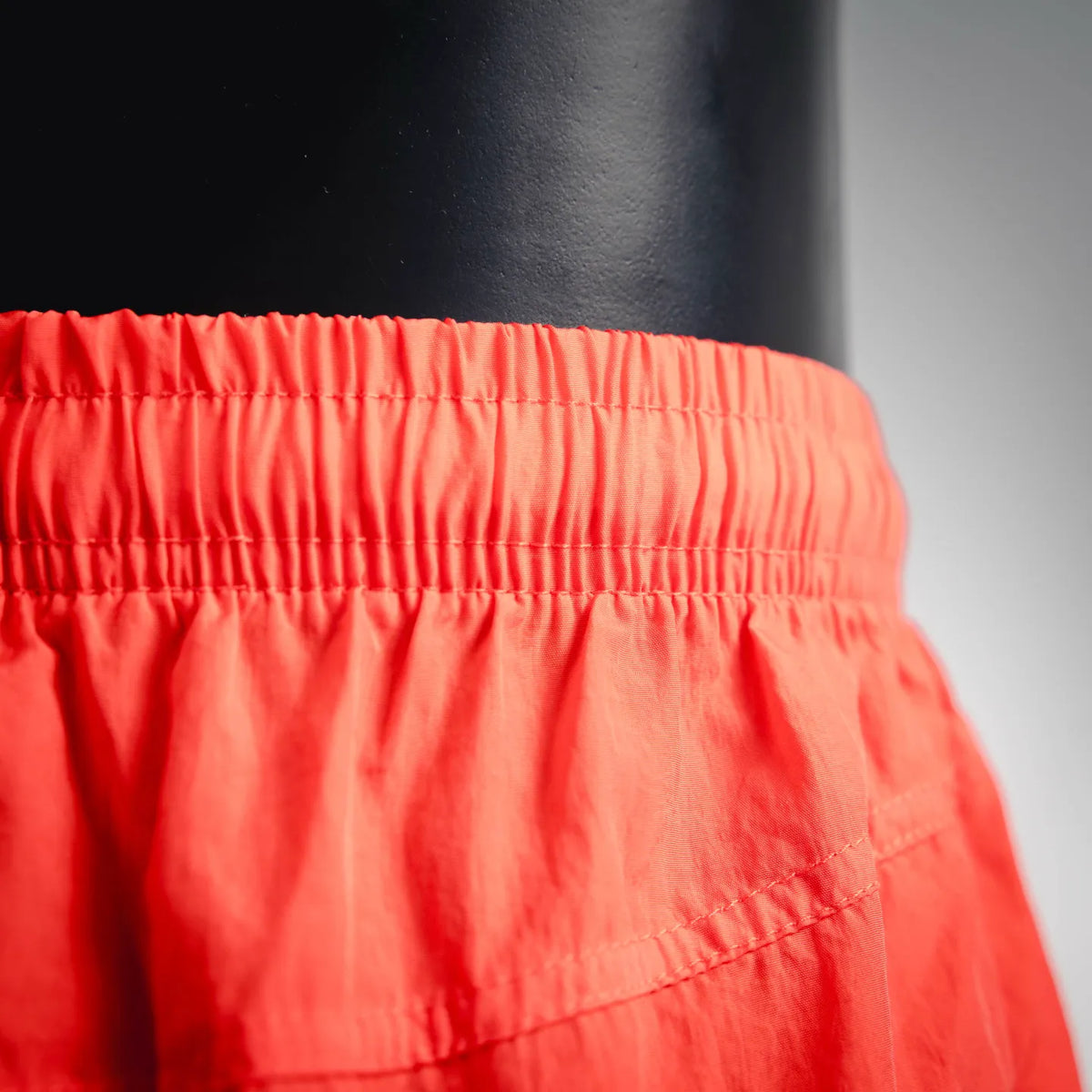 Red shorts front pocket area with elastic waist and curved seam detail