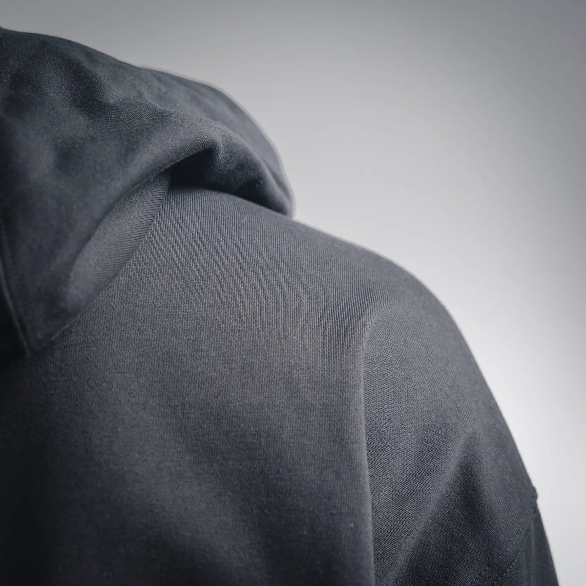 Black zip-up hoodie fabric and hood seam close-up