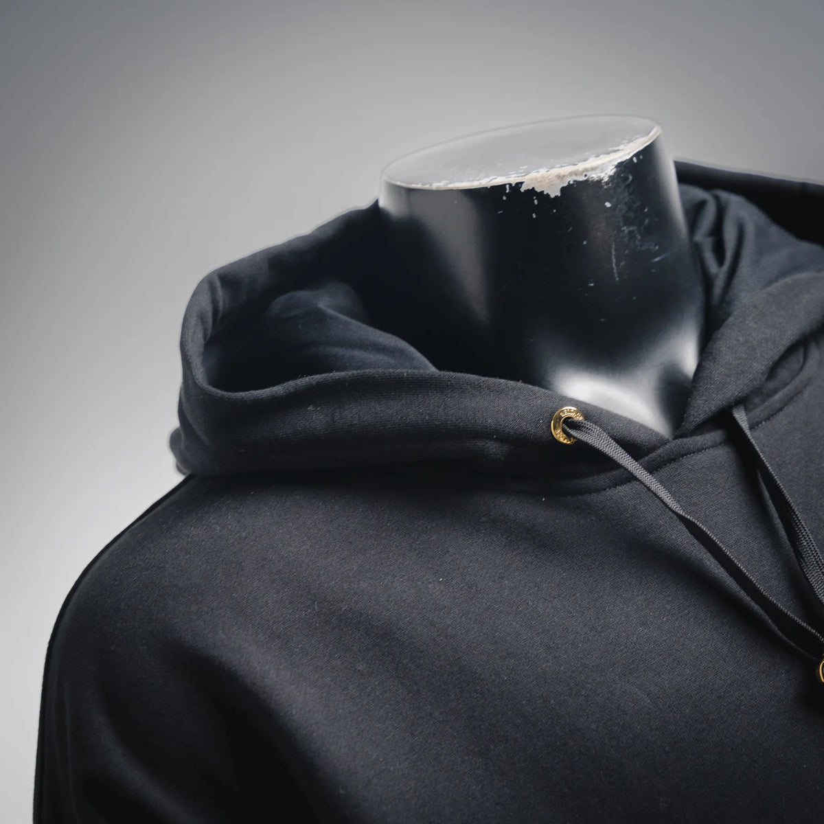 Black hoodie hood with drawstring and gold zipper detail