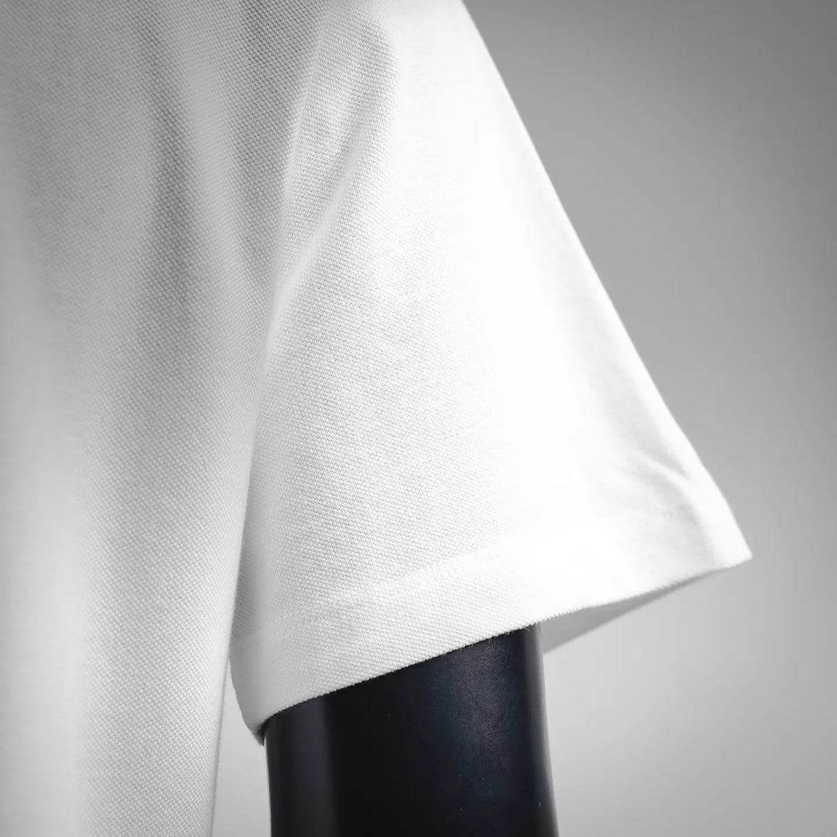 White polo shirt side view with short sleeve opening and straight hem