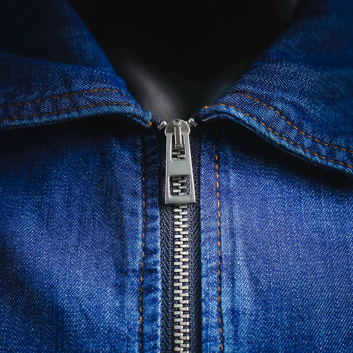 Front metal zipper and stitched placket detail on denim jacket