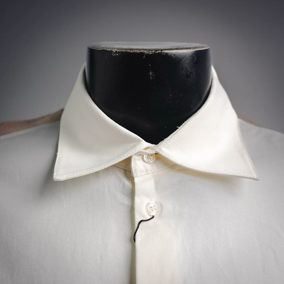 White shirt collar with top button close-up and stitched neckline