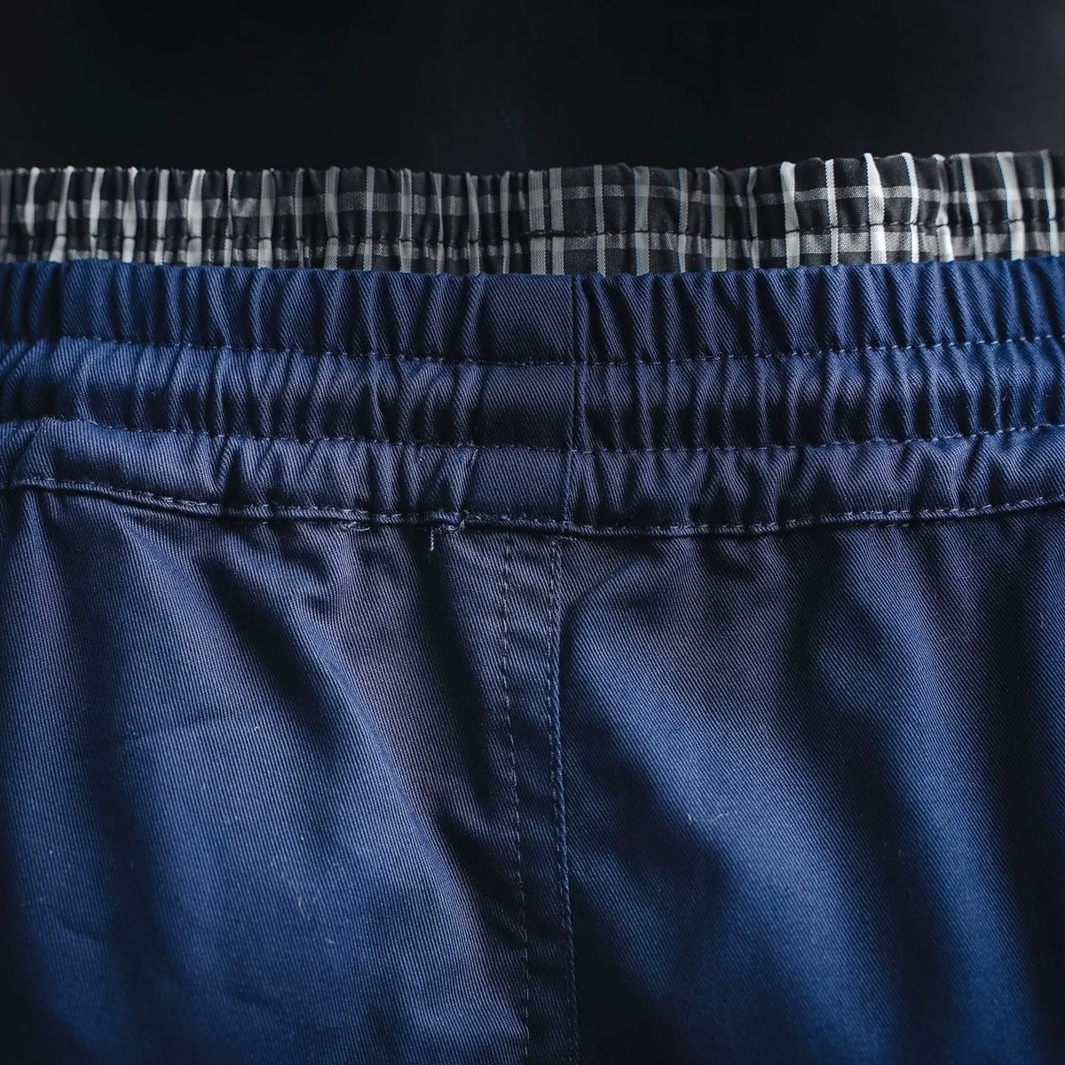 Blue shorts waistband with elastic and black-and-white check inner trim