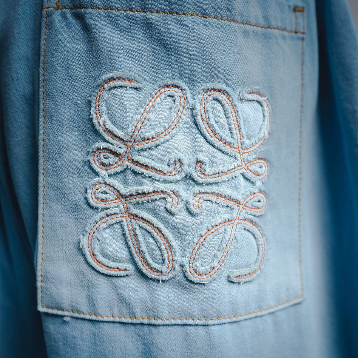 Light blue denim pants with embroidered patch on the front pocket
