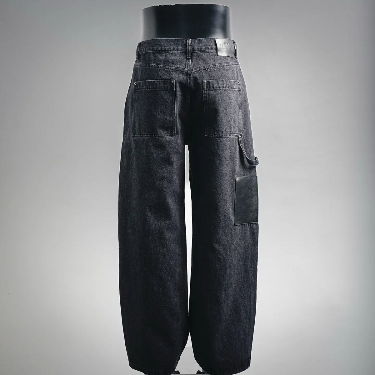 Dark denim LOEWE pants, back view, with patch pockets and buttoned waistband