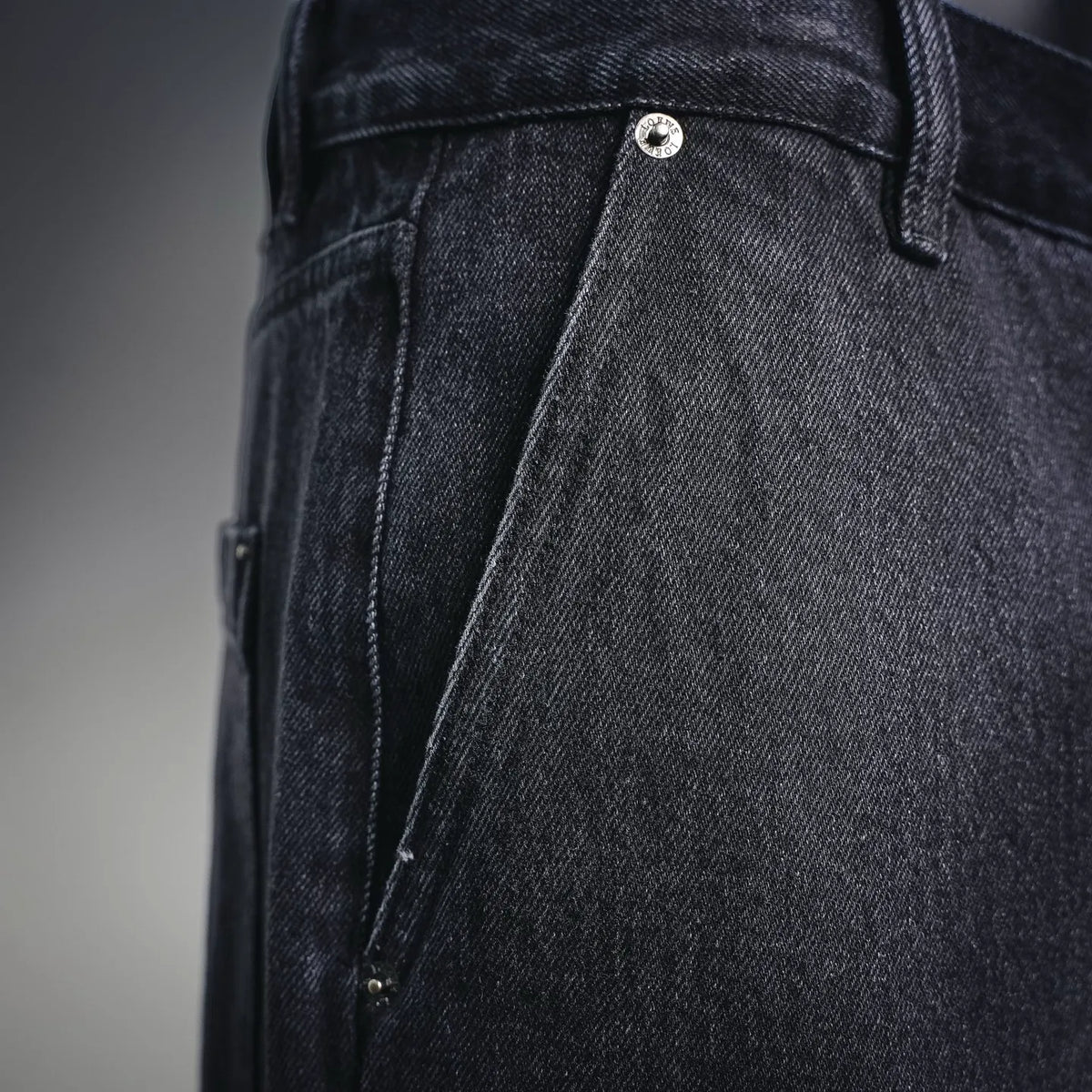 Dark denim pants front with belt loops, button closure, and side pocket
