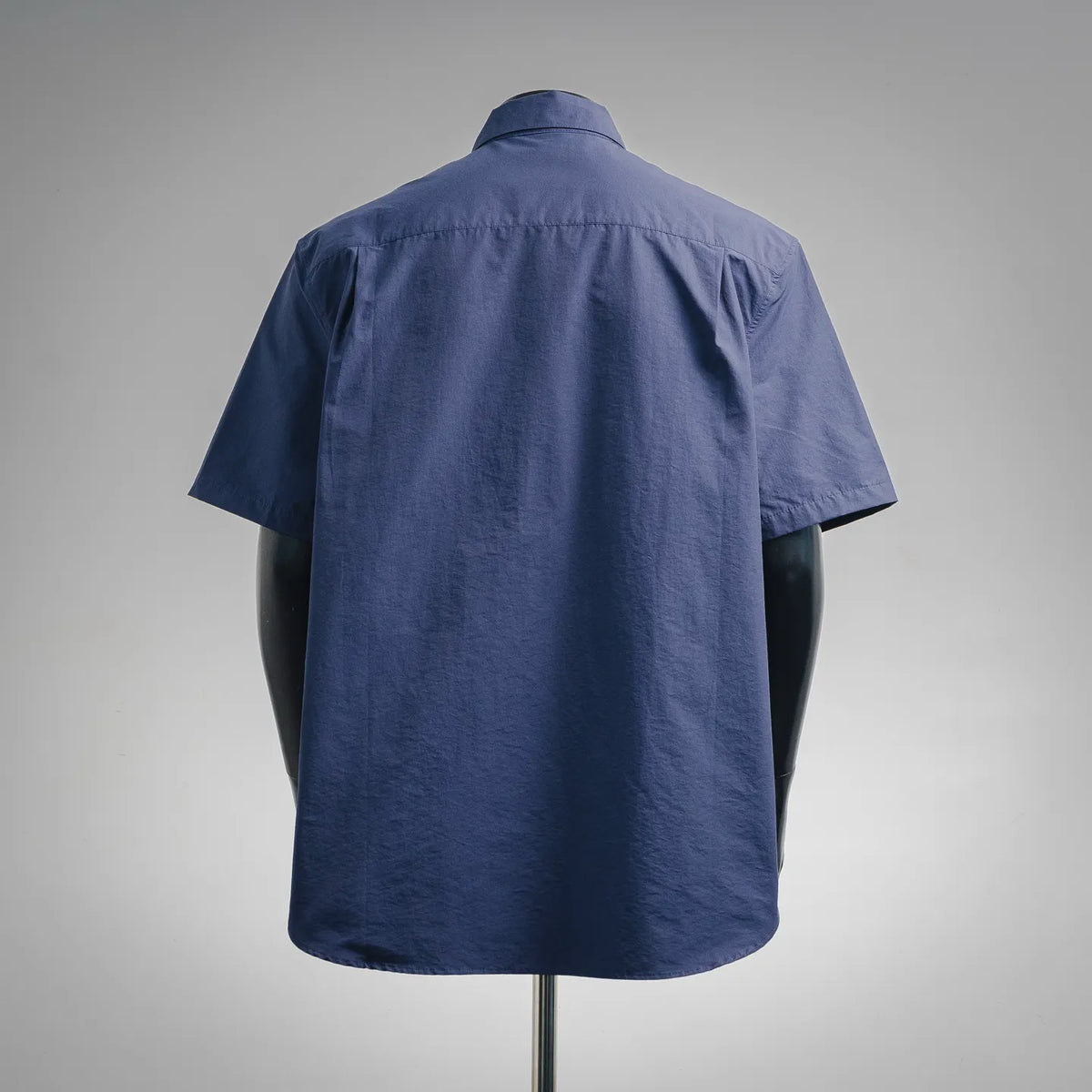 Blue short-sleeve button-up shirt, back view with pointed yoke seam