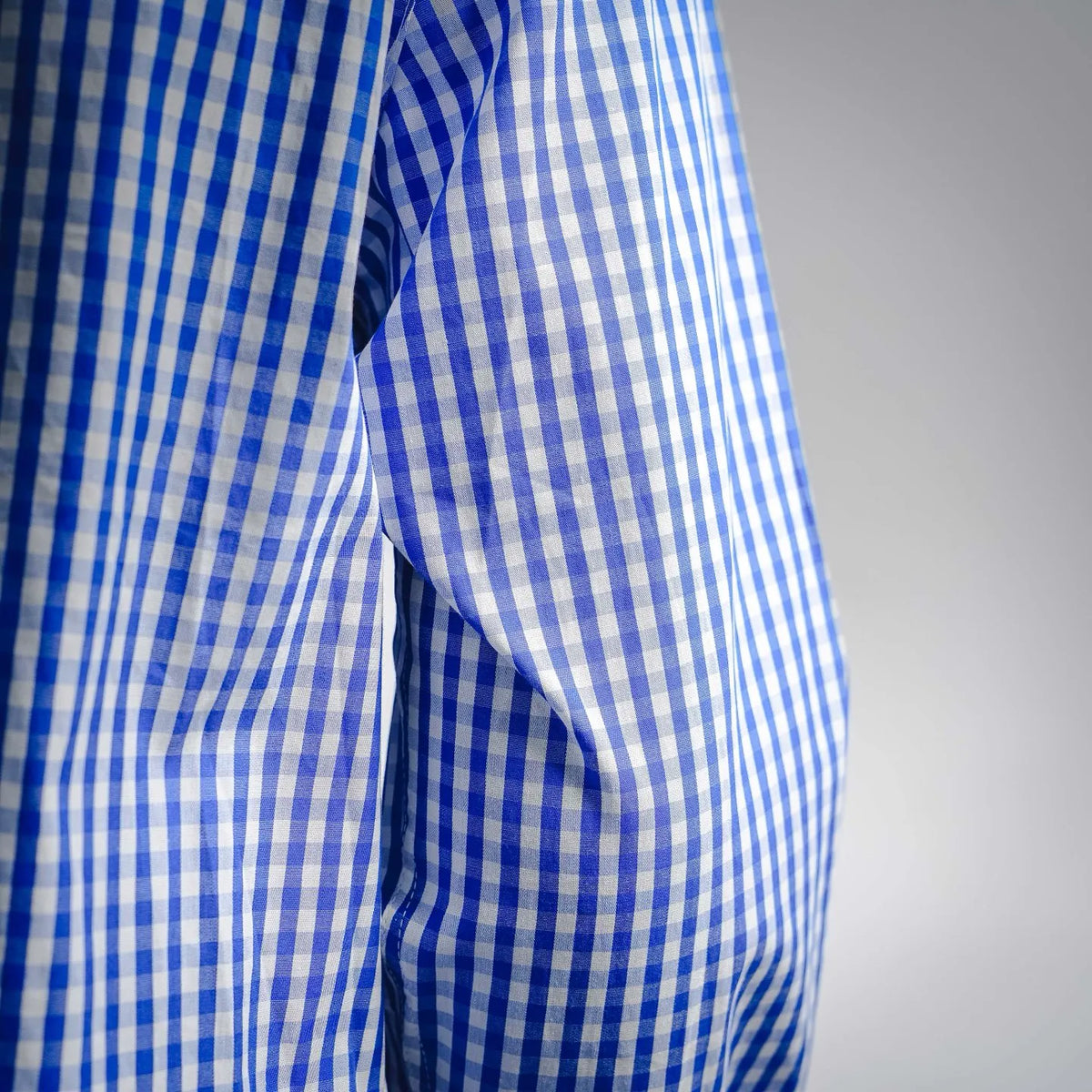 Blue and white check shirt fabric with sleeve fold detail.