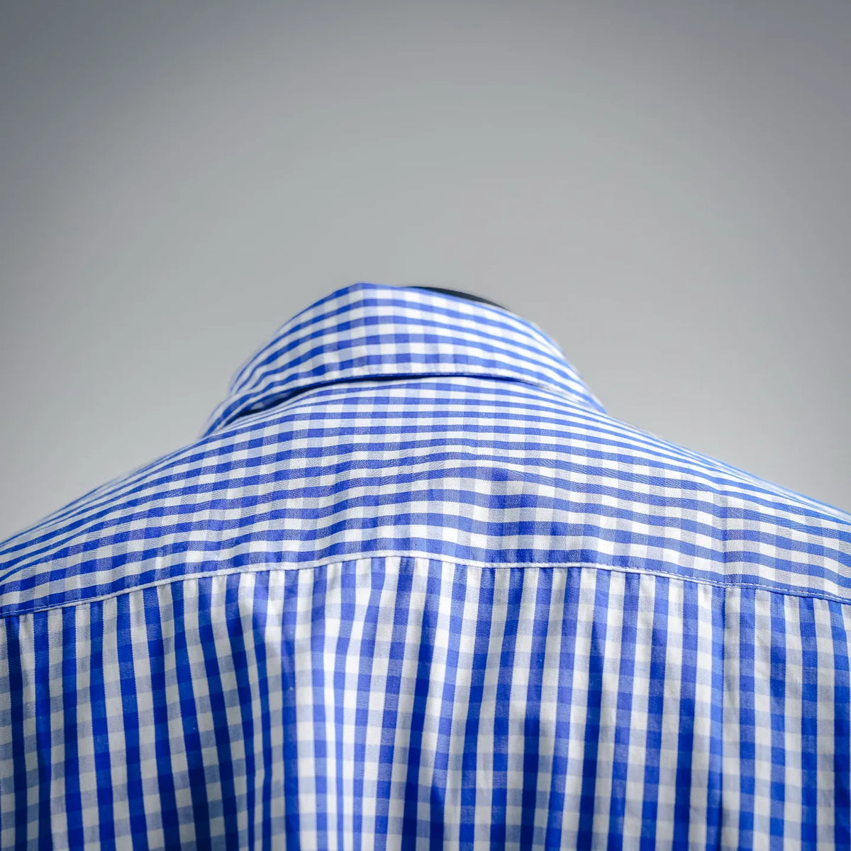 Blue and white check shirt collar and back yoke detail.