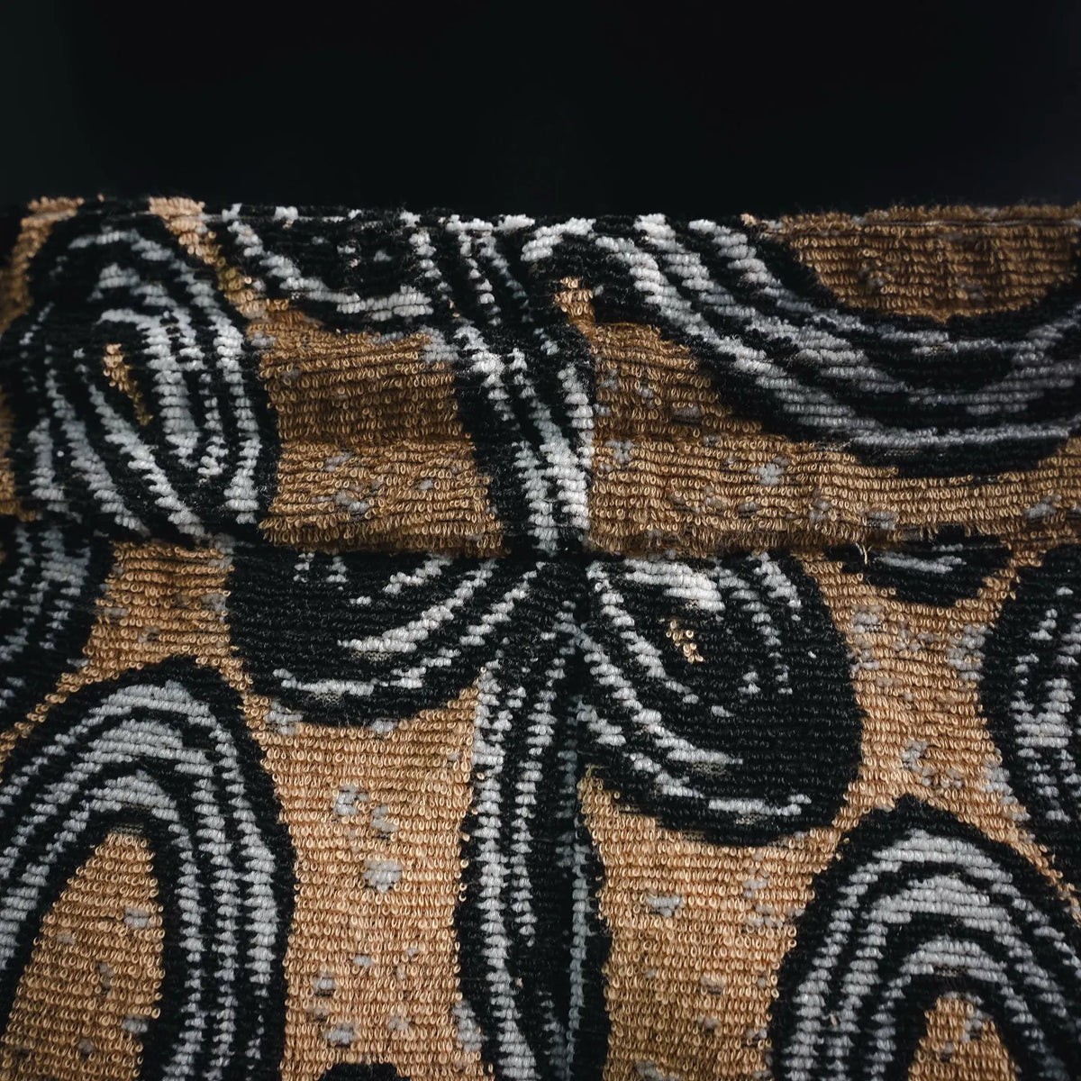 Close-up of tan fabric with black and white abstract pattern