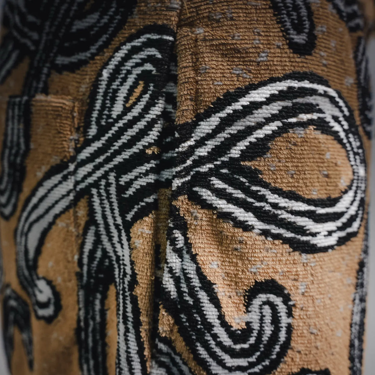 Close-up of tan textile with black and white swirl motif