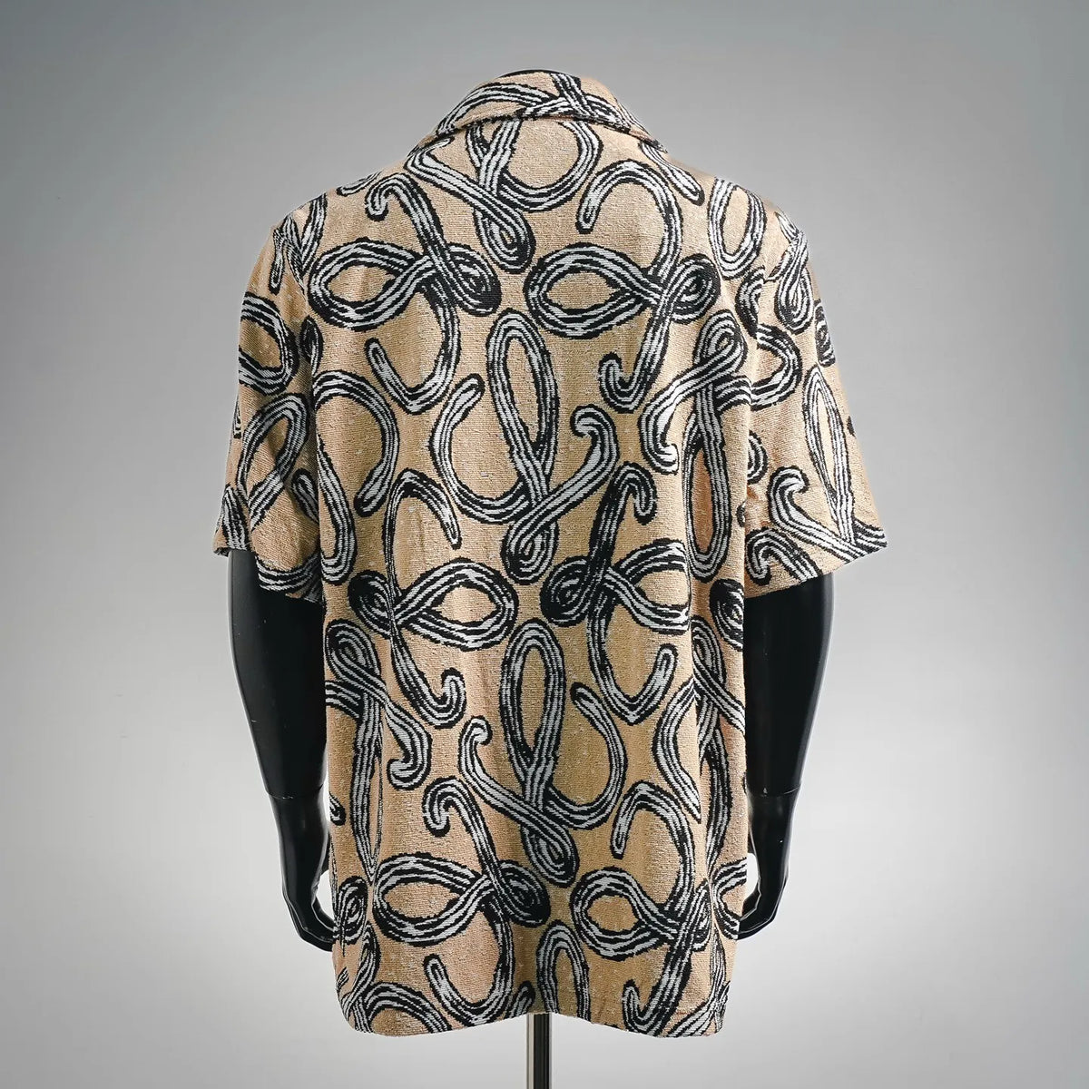 Men's short-sleeve button-up shirt, back view, abstract black-and-tan pattern