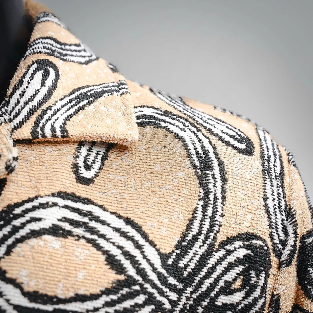 Shoulder and upper front of short-sleeve button-up shirt with black-tan pattern