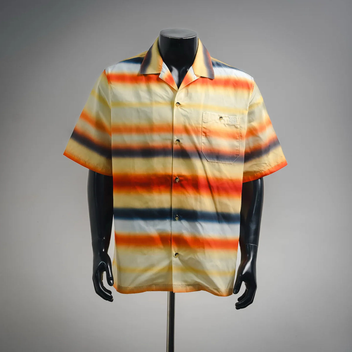 Short-sleeve button-up shirt with orange, blue, and cream horizontal stripes