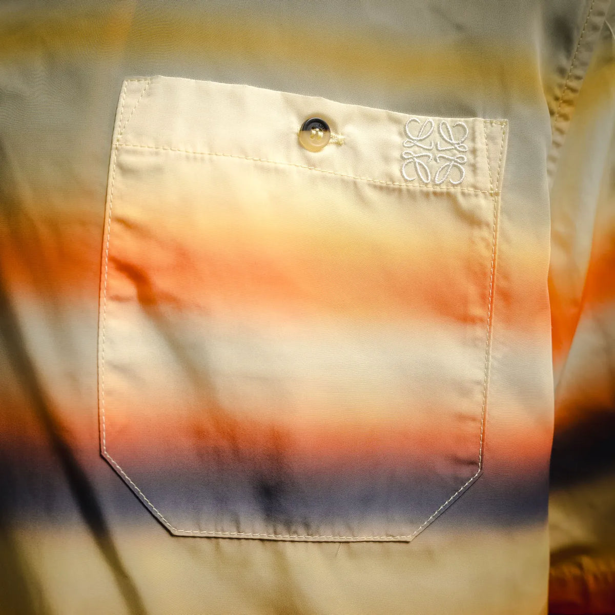 Embroidered logo patch and pocket on striped short-sleeve button-up shirt