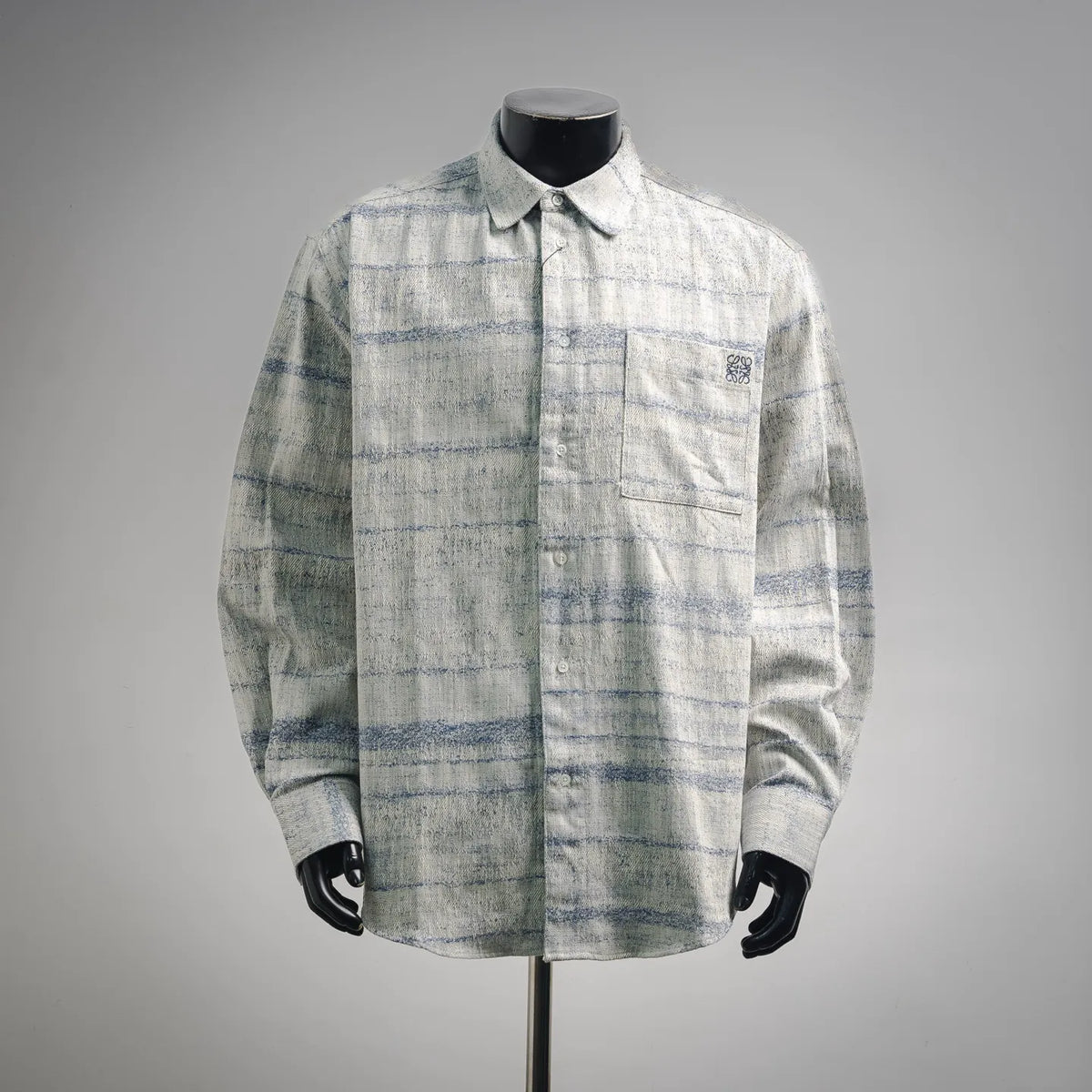 Long-sleeve button-up shirt in light blue and white plaid, with pointed collar