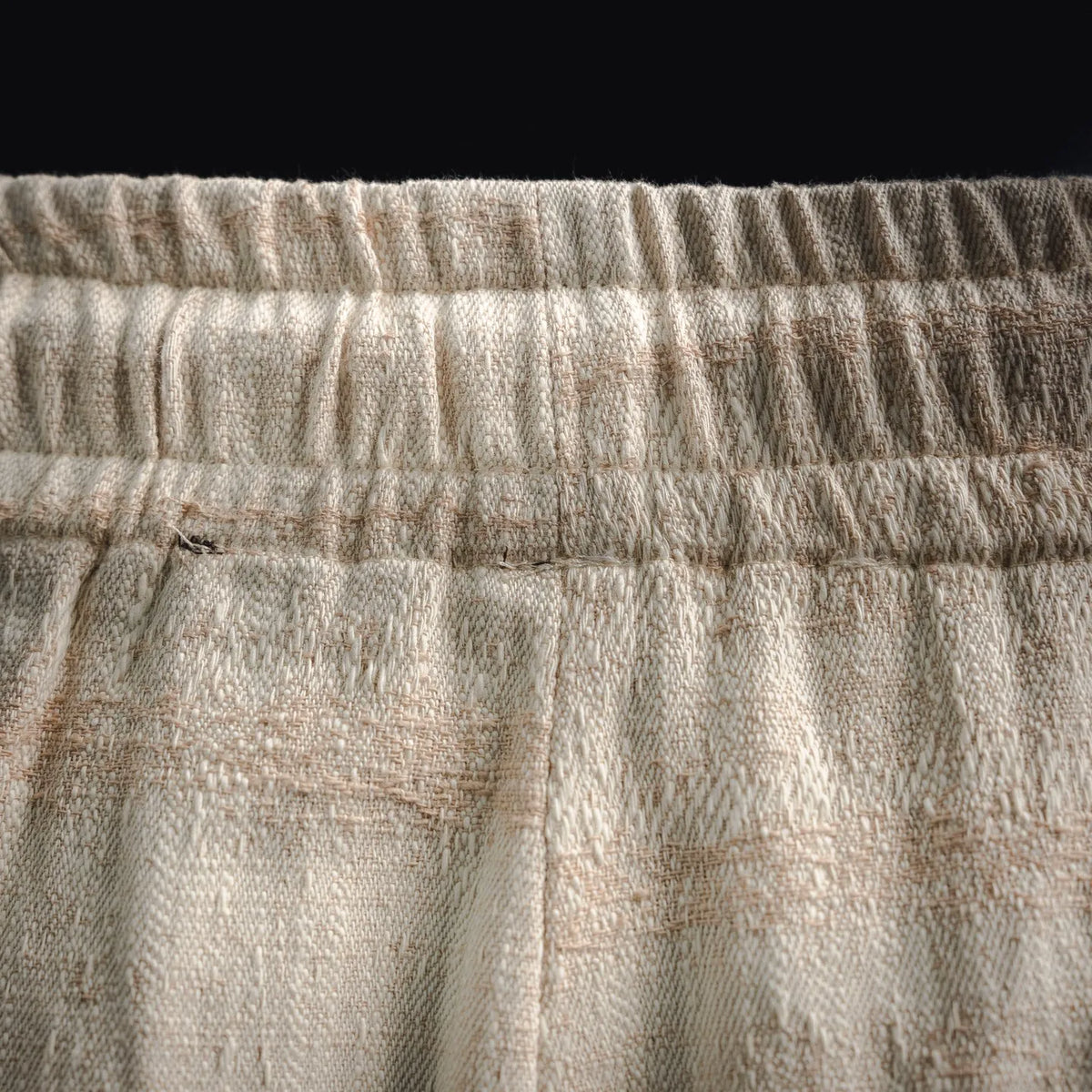 Close-up of elastic waistband on off-white linen shorts