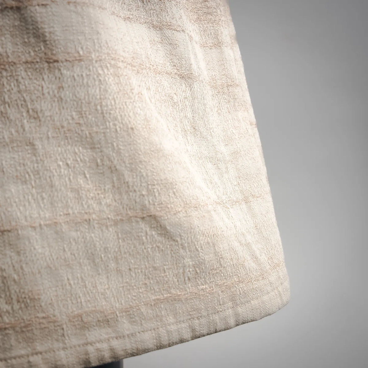 Hem of off-white linen shorts with slightly flared, clean finish