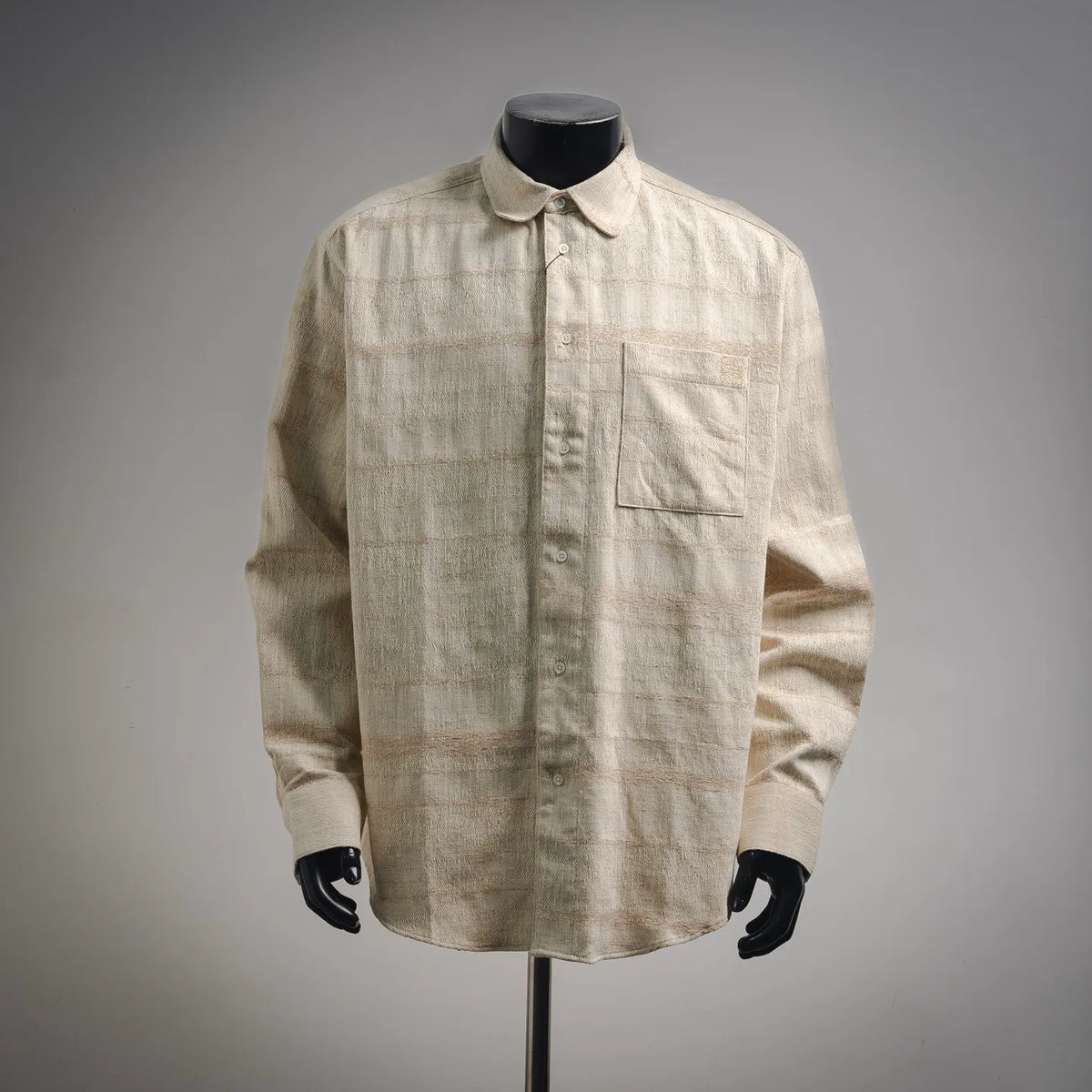 Beige long-sleeve button-up shirt with pointed collar and chest pocket.