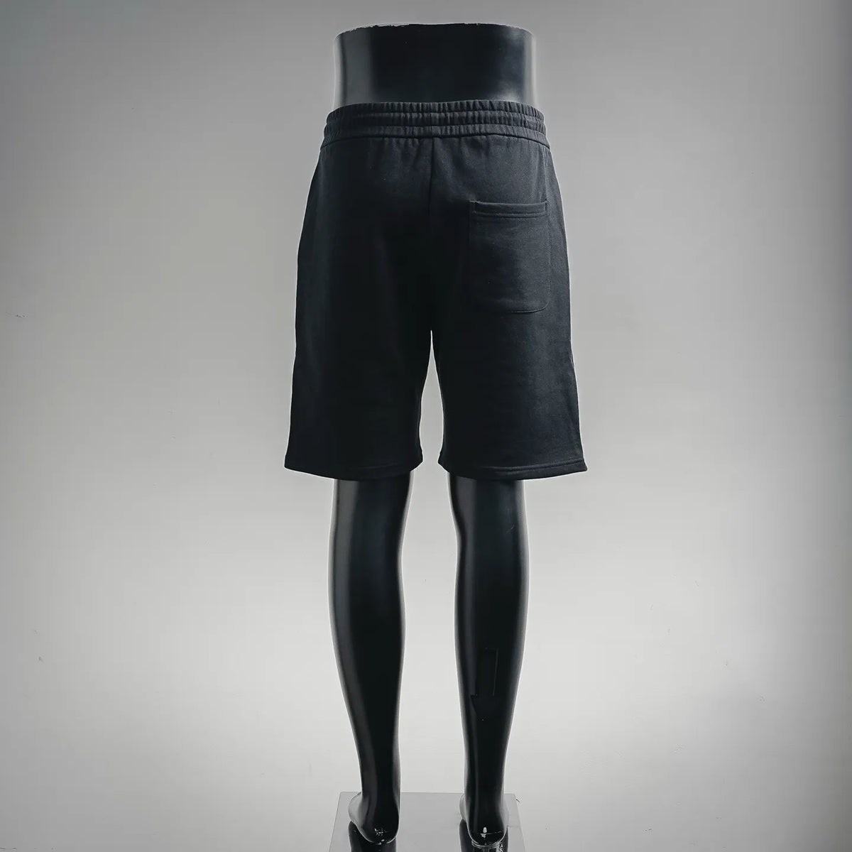 Black drawstring shorts with elastic waistband and straight knee-length legs