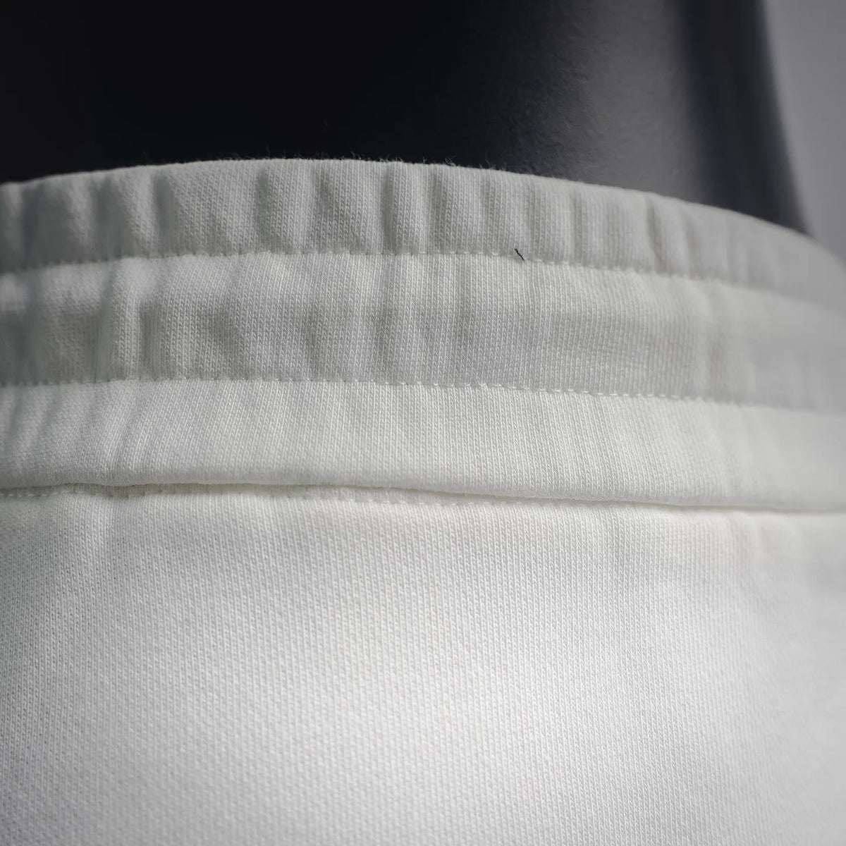 White shorts waistband close-up with elastic and fabric texture
