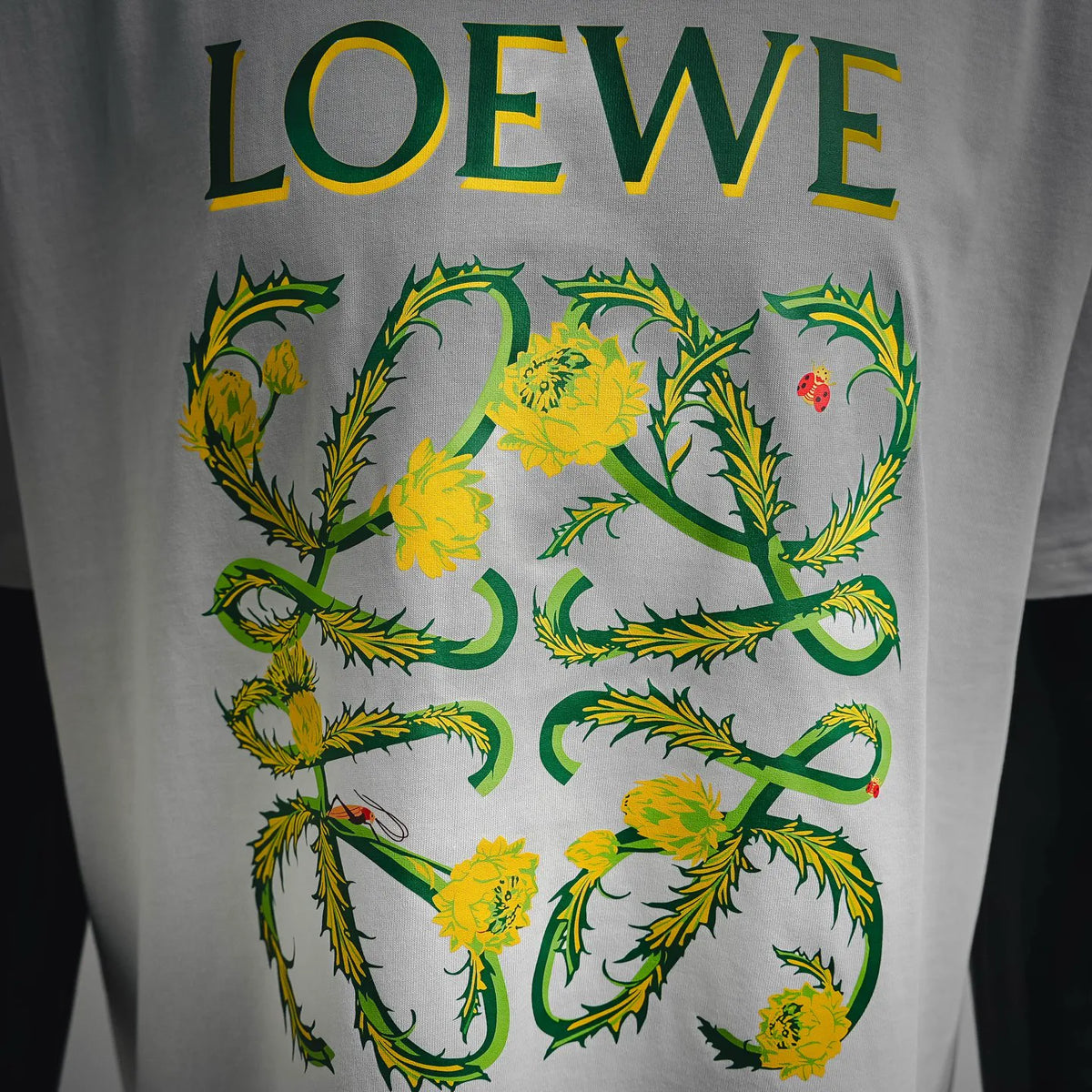 White LOEWE T-shirt with large green and yellow floral logo print.