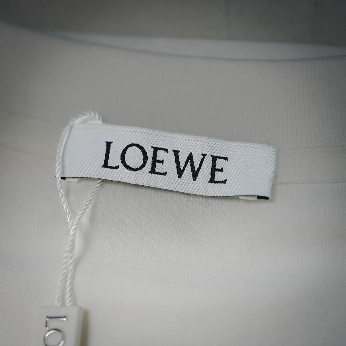 White LOEWE T-shirt interior neck label with LOEWE text.