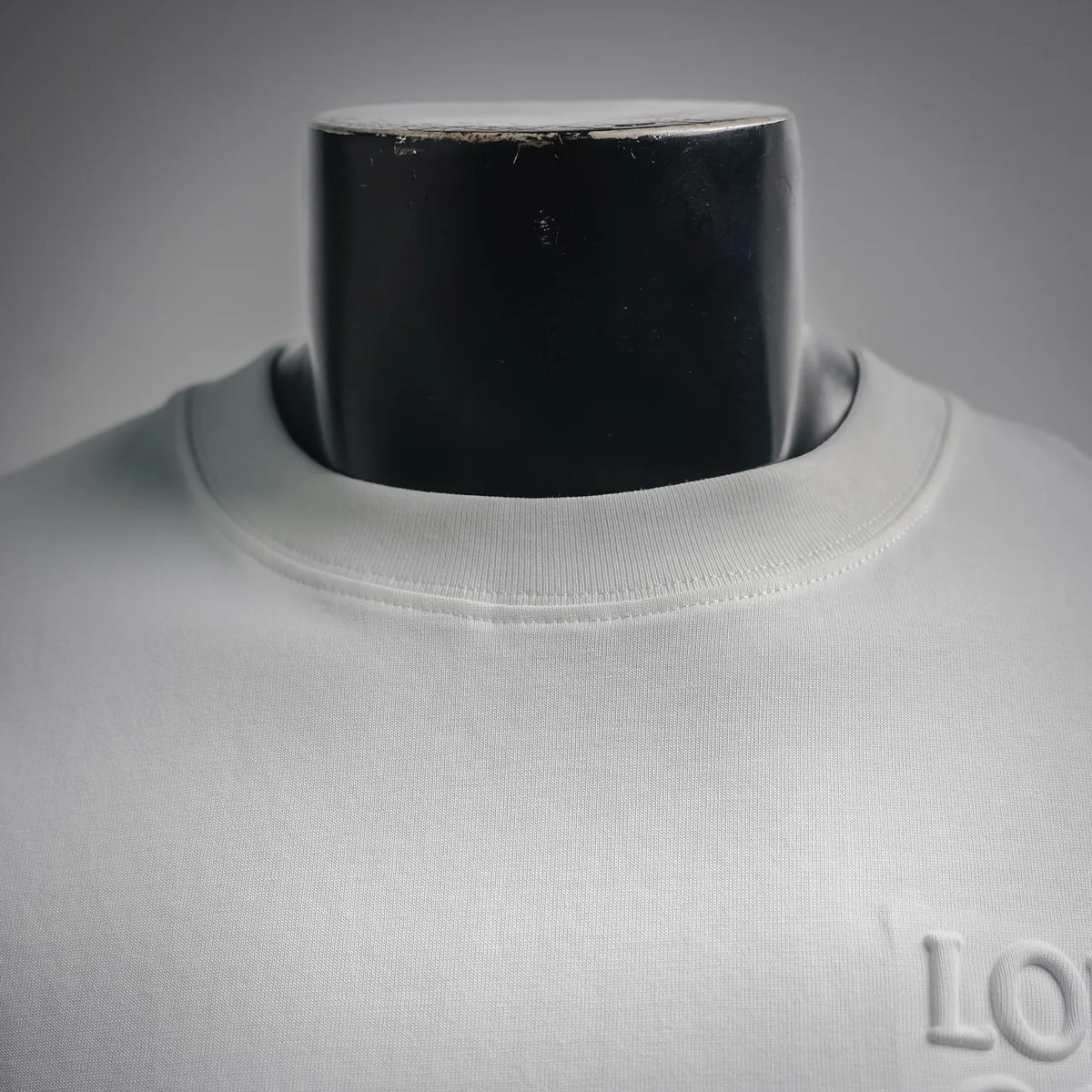 White crew-neck T-shirt with ribbed collar close-up.