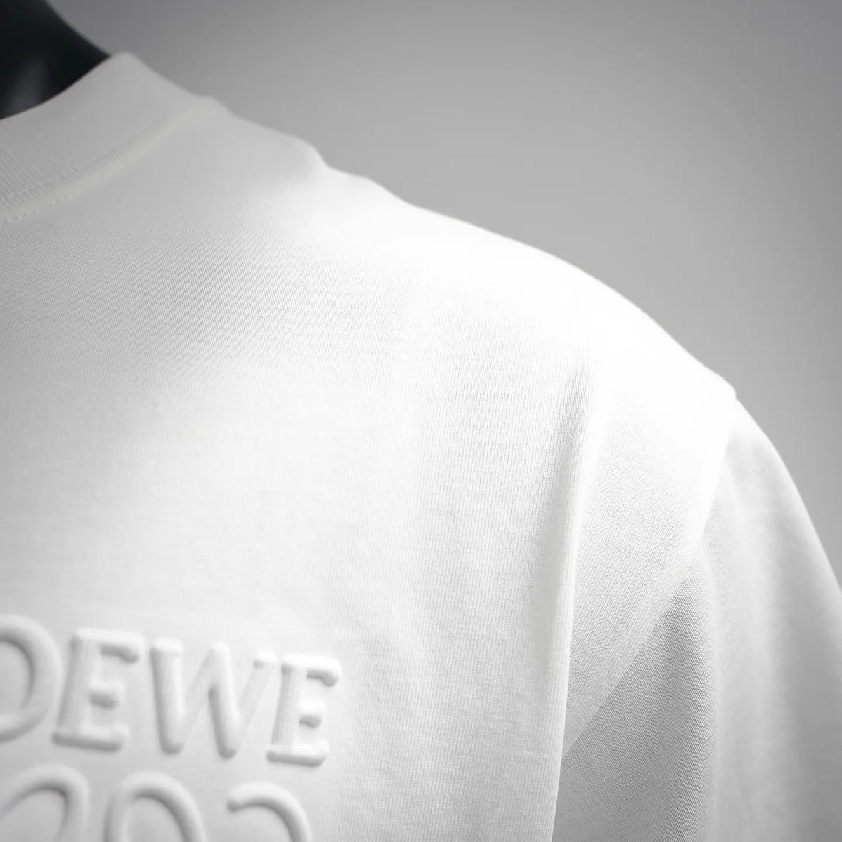 White short-sleeve T-shirt with partial LOEWE logo detail.