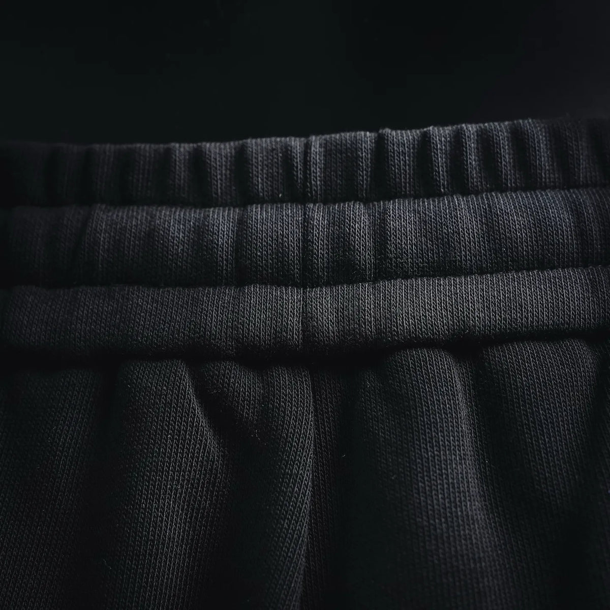 Black elastic waistband with textured knit and stitched top edge