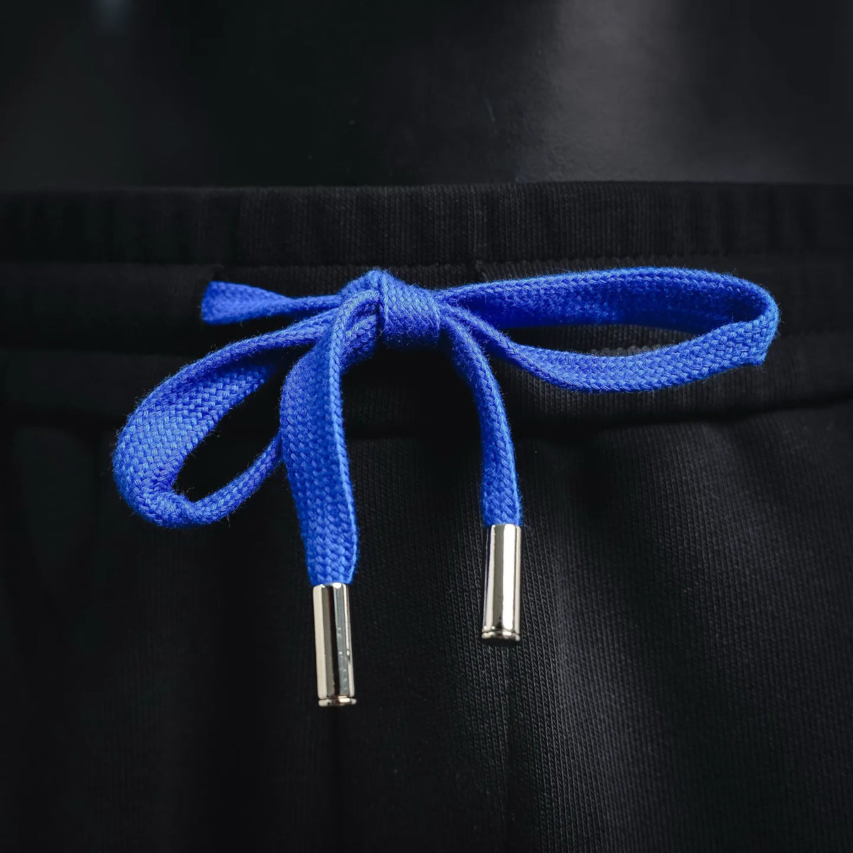 Black shorts with bright blue drawstring and silver metal aglets