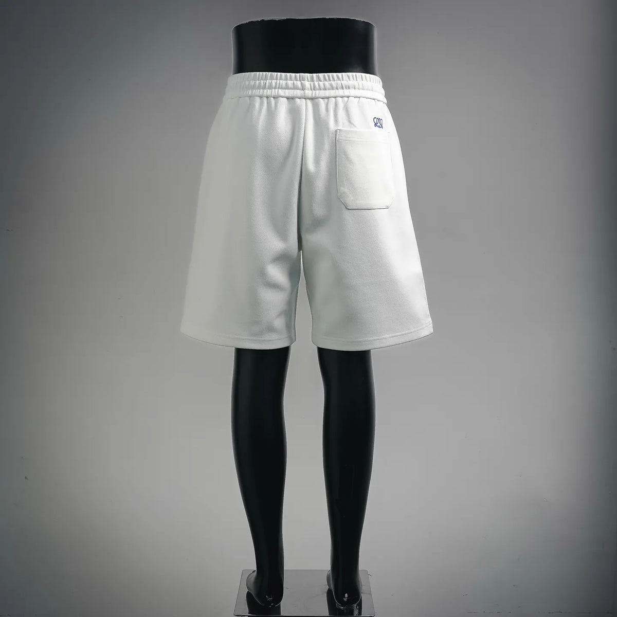 White LOEWE drawstring shorts on mannequin, back view, elastic waistband, pocket.