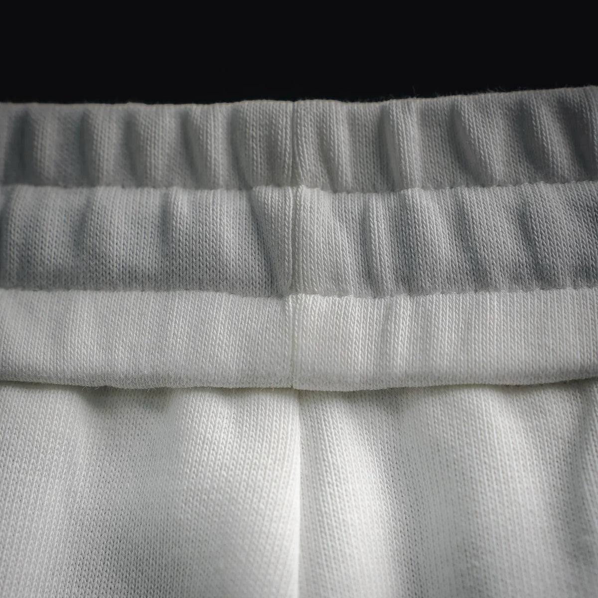 White LOEWE elastic waistband close-up with gathered fabric and stitching.