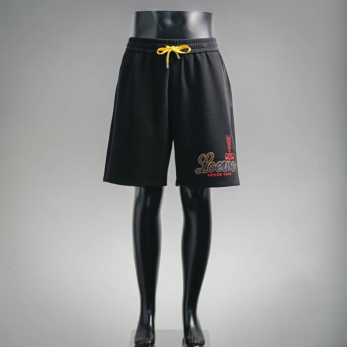 Black drawstring shorts with yellow tie, relaxed fit and elastic waistband
