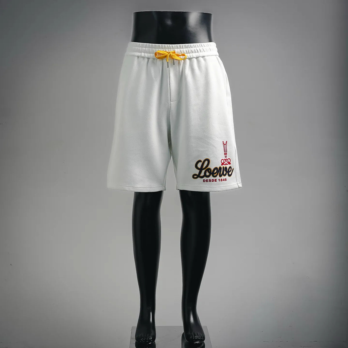 White LOEWE shorts with yellow drawstring and embroidered logo on front hem
