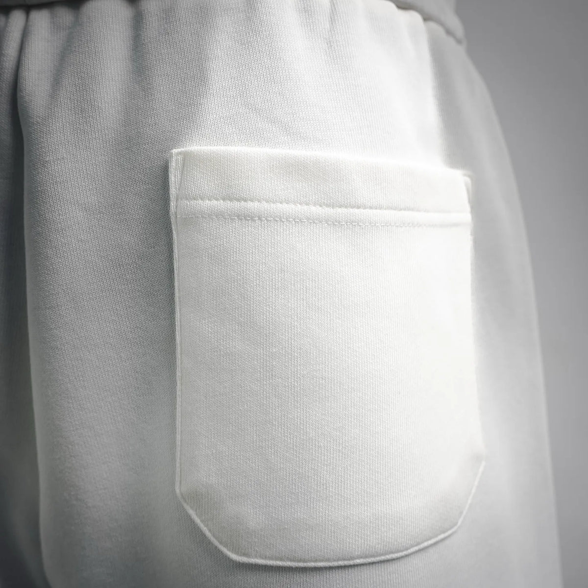 White LOEWE shorts side seam with front patch pocket close-up