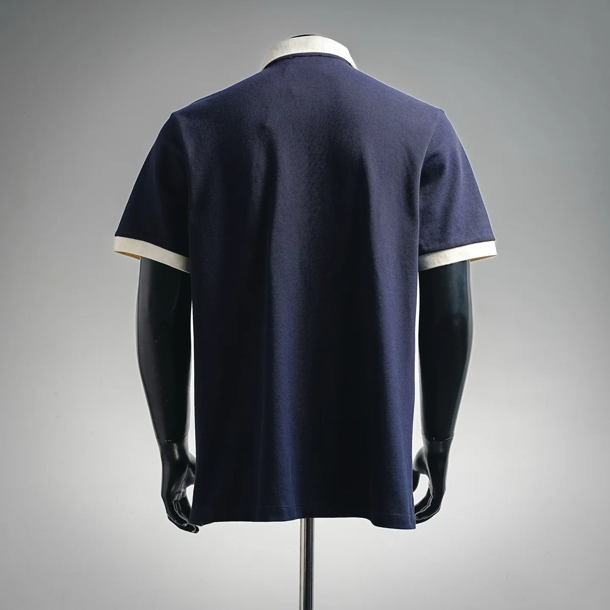 Navy LOEWE polo shirt, back view with white sleeve cuffs