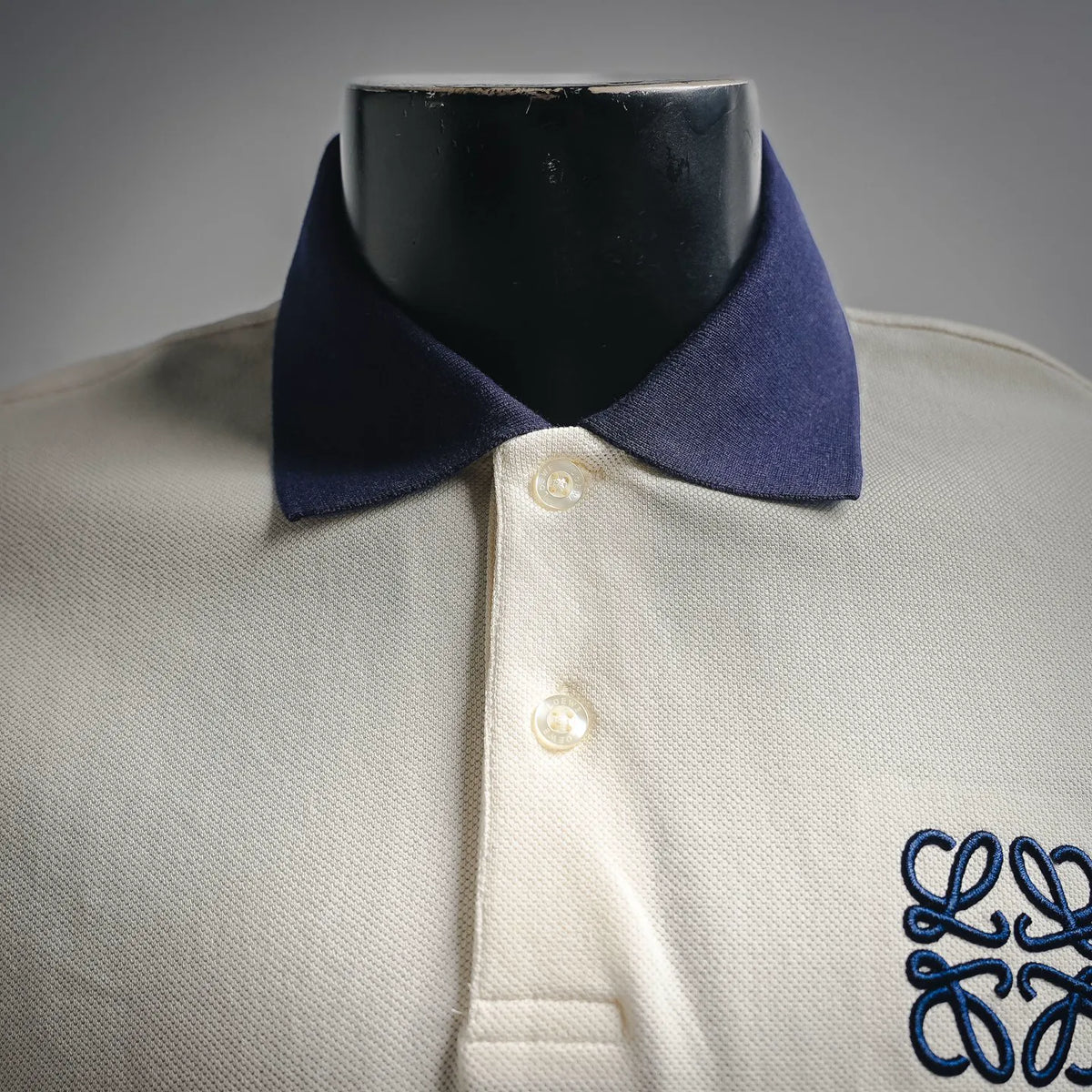 LOEWE polo shirt neckline with navy collar, two buttons, and partial front logo