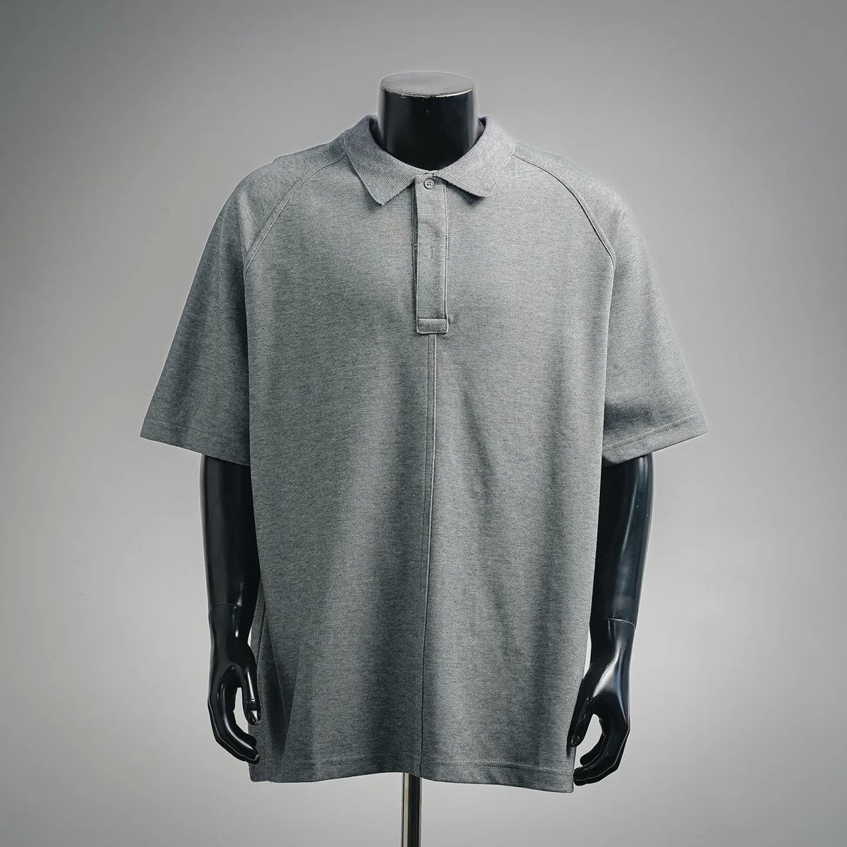 Heather gray short-sleeve polo shirt on mannequin, button placket and collar