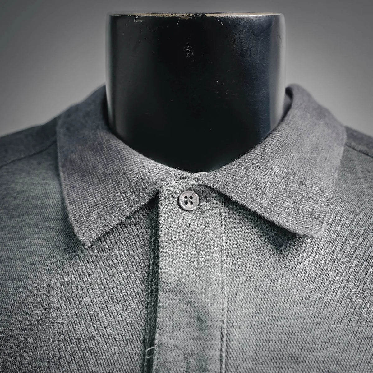 Heather gray polo shirt neckline and collar with round button at placket