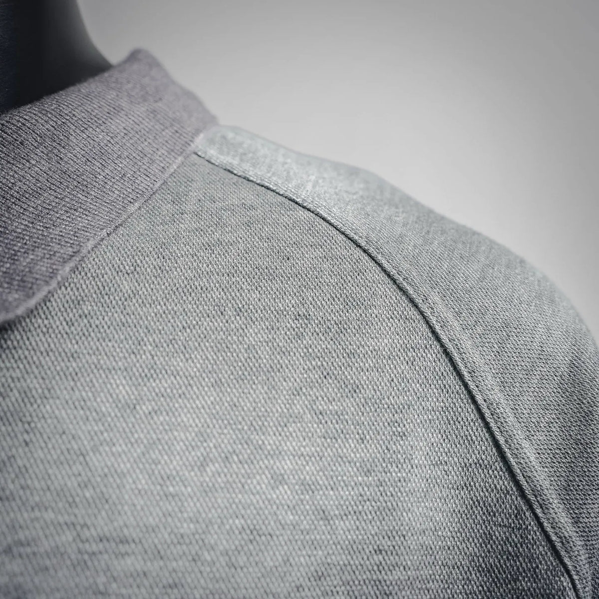 Shoulder seam detail on a heather gray short-sleeve polo shirt