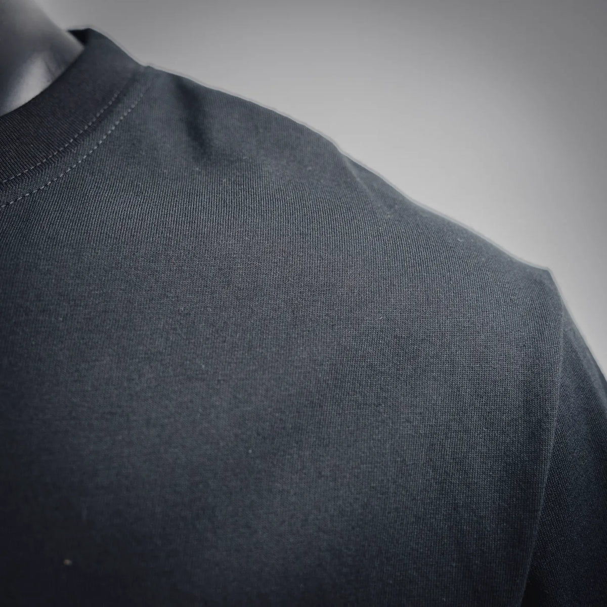 Black crewneck T-shirt shoulder and upper sleeve fabric close-up
