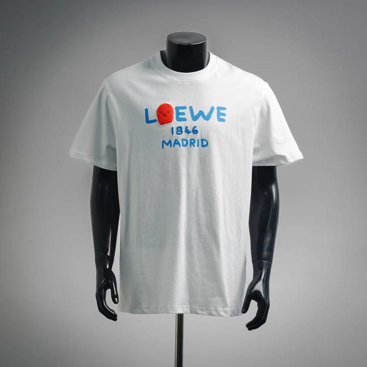 White LOEWE T-shirt with blue “LOEWE 1846 MADRID” graphic and red lion logo