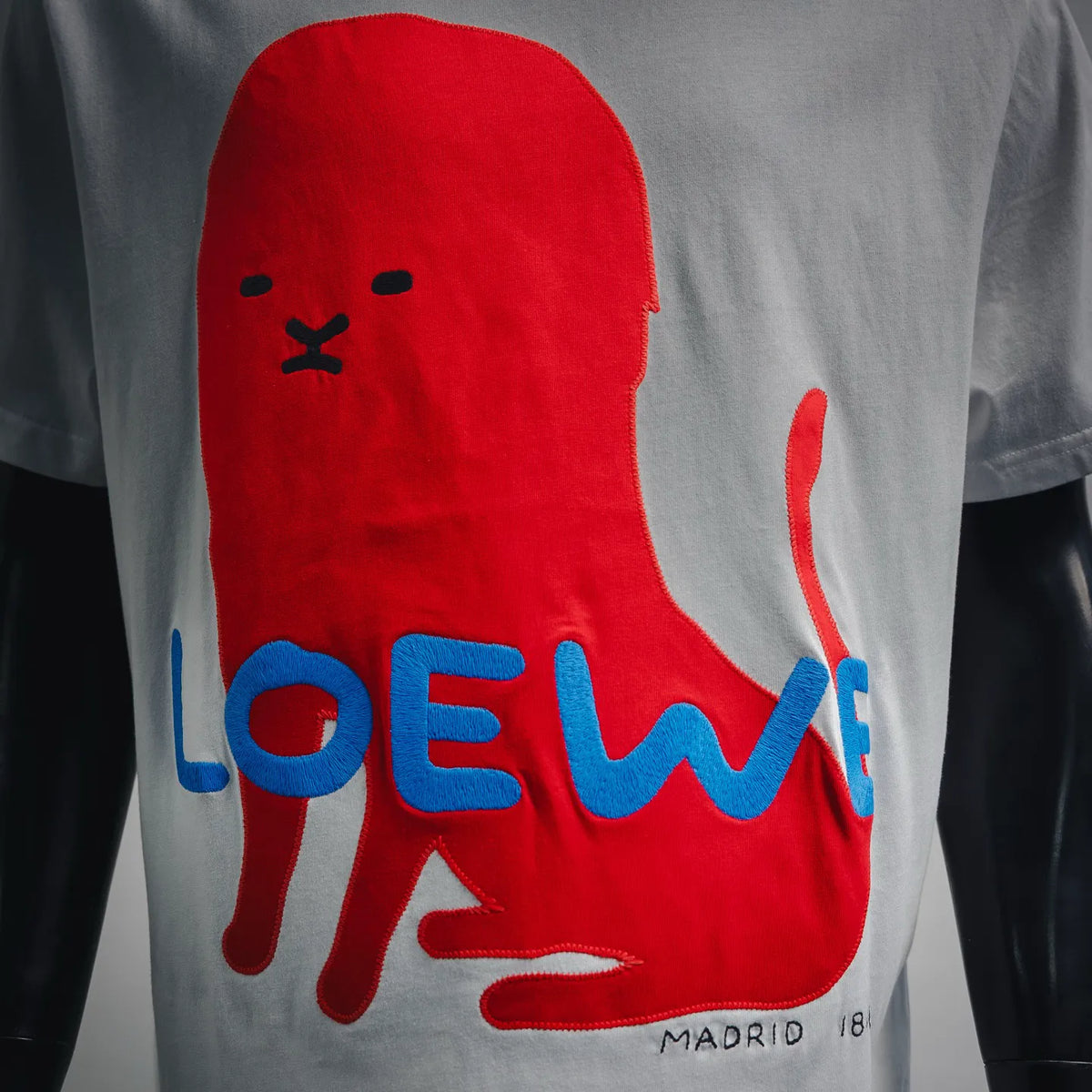LOEWE white T-shirt close-up: red bear with blue LOEWE lettering