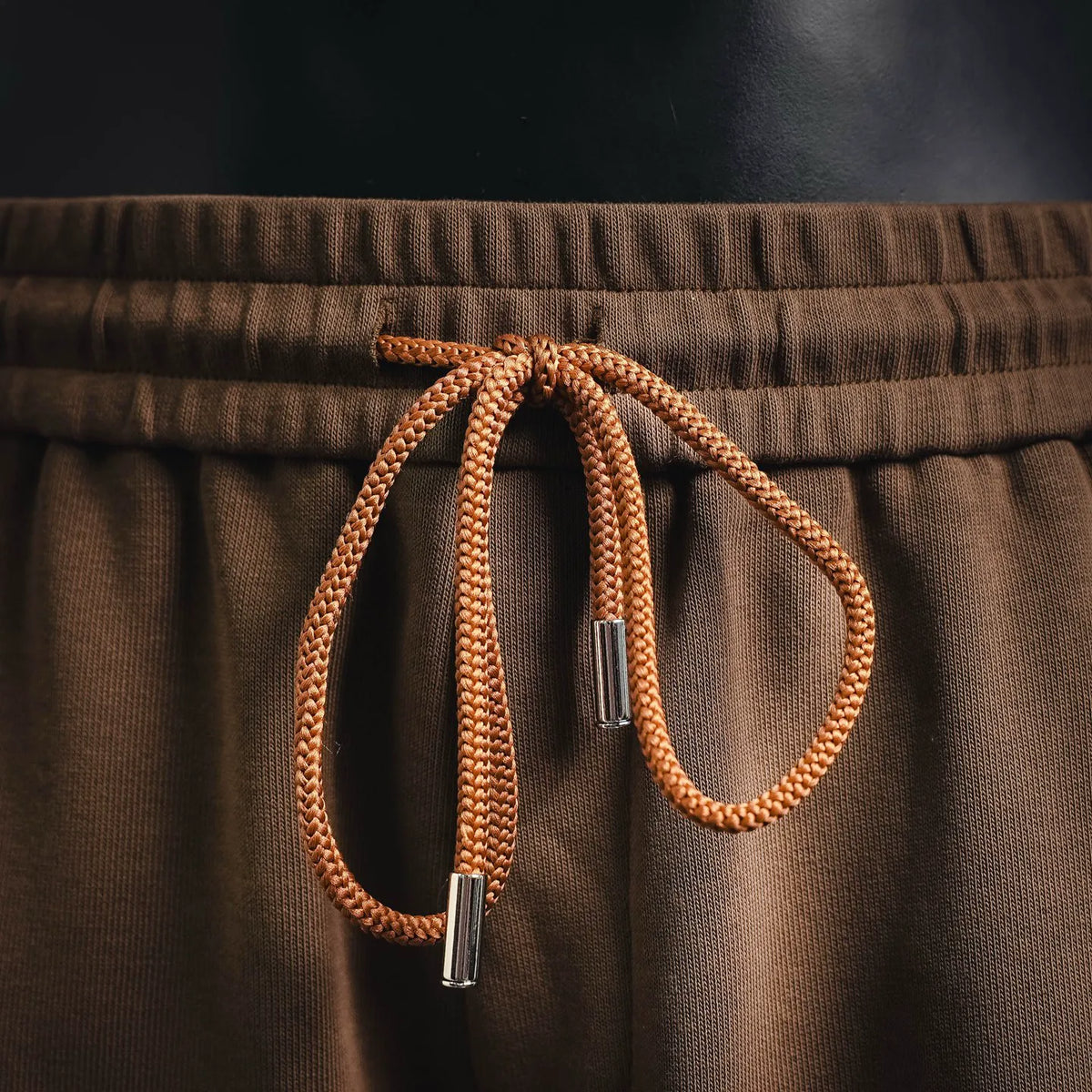 Tan cotton shorts with braided drawstring and metal aglets at waistband