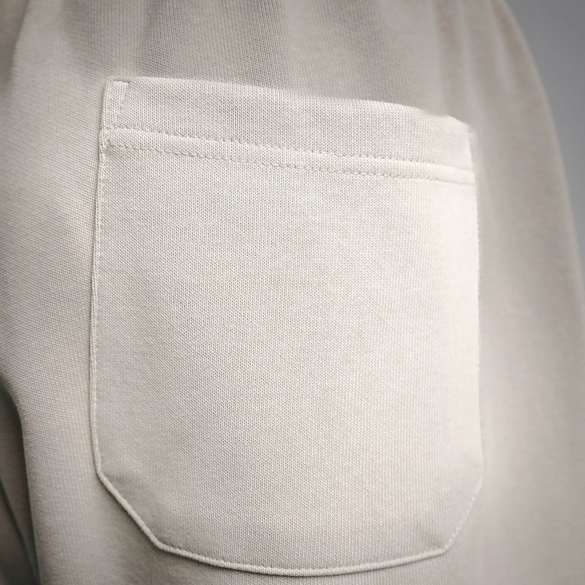 Light cream shorts front pocket panel with curved stitch detail