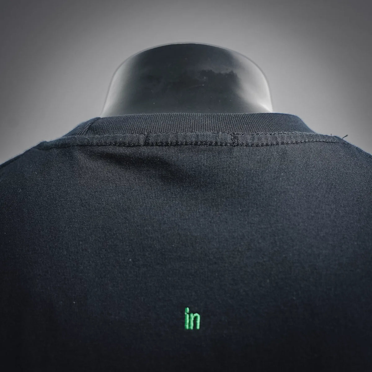 Navy short-sleeve T-shirt collar with small 'in' mark on upper back